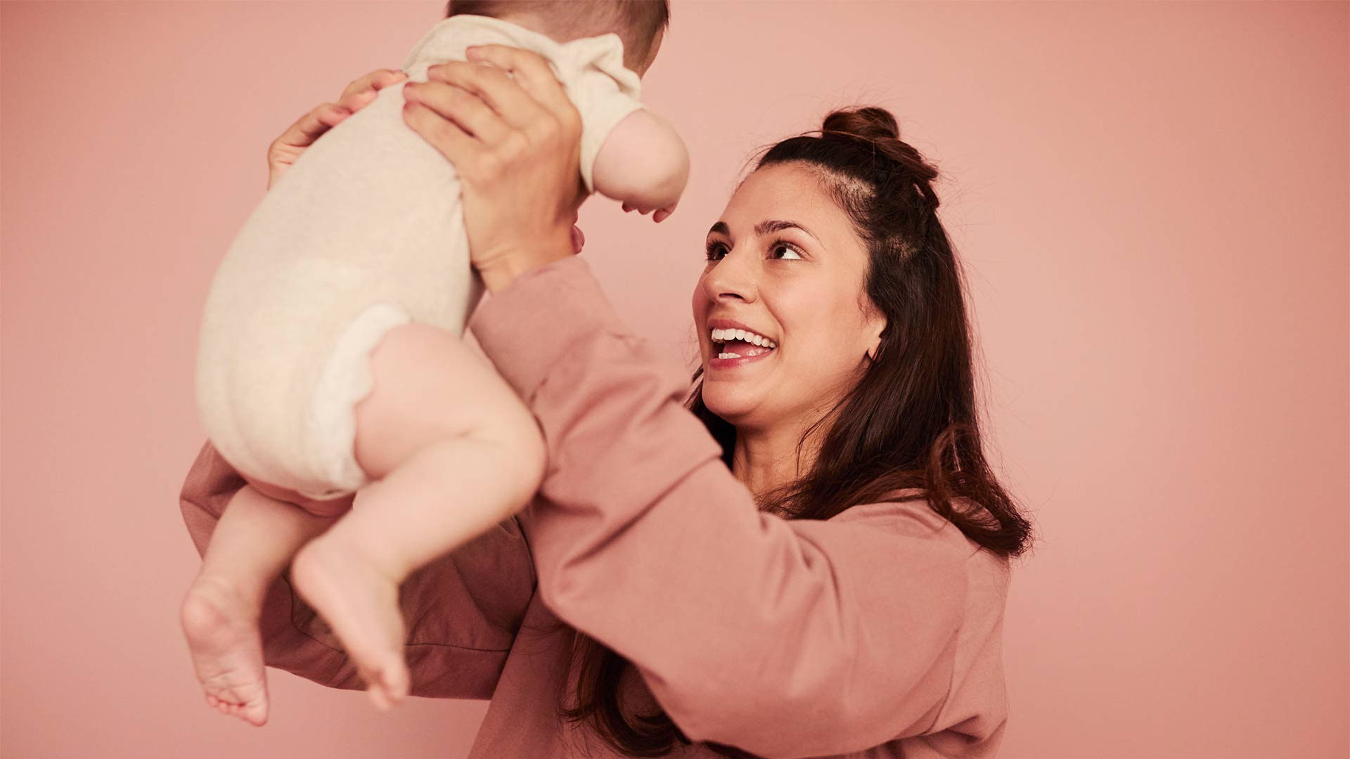 Mujer sosteniendo a su bebe en el aire